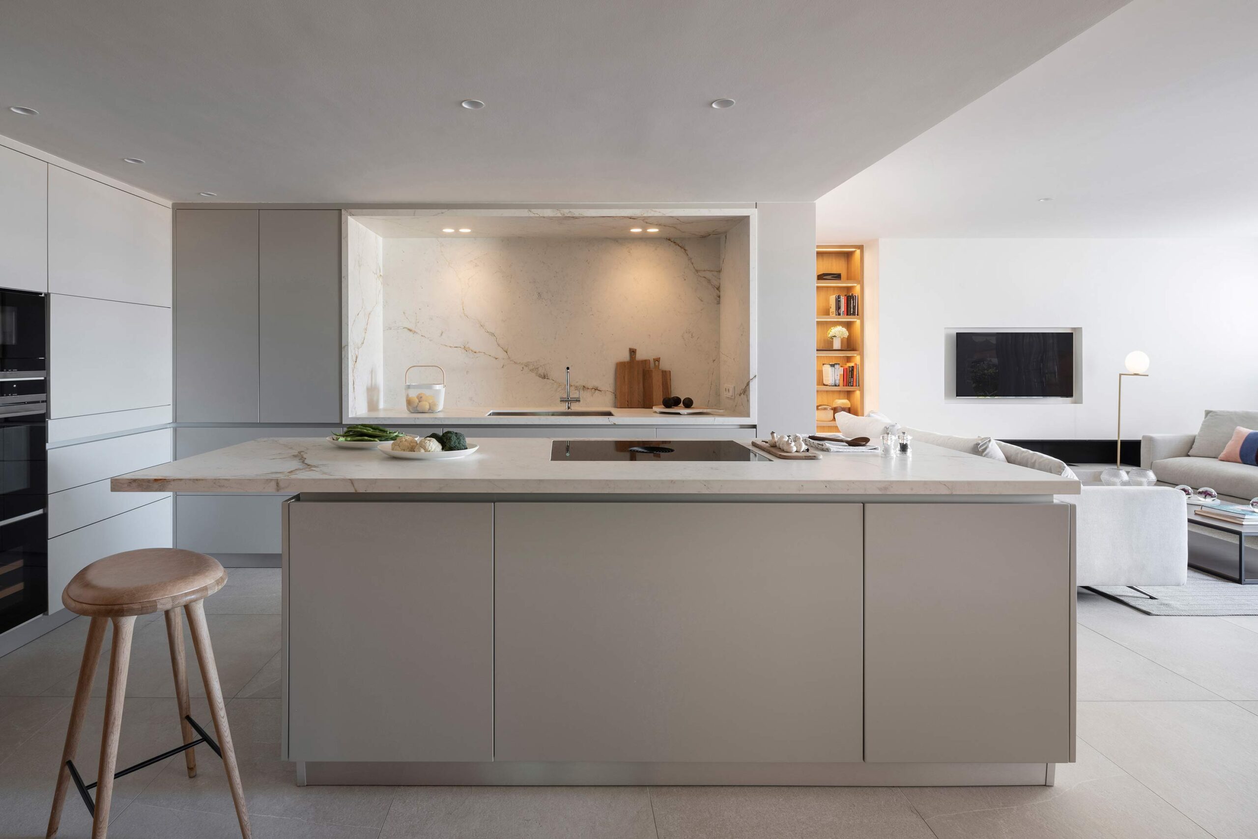 Cocina abierta reformada con isla de mármol y salón